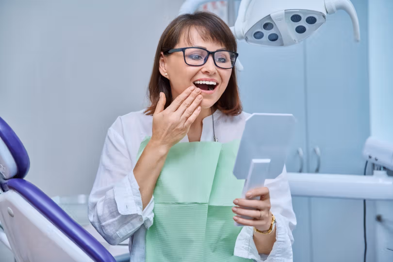 Dental patient admiring her smile in a mirror